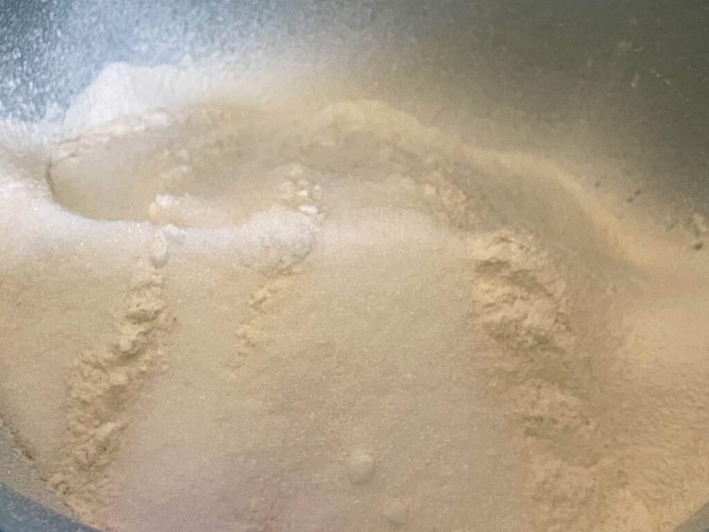 Flour, baking powder and sugar in light green bowl.