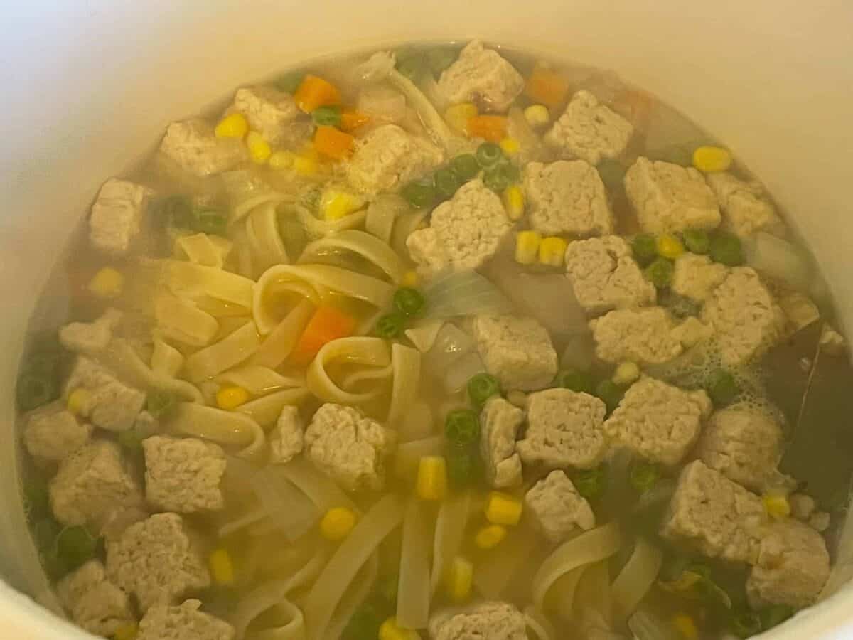 Noodle soup cooking in pot.