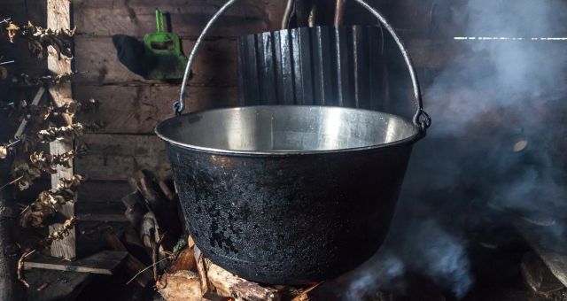An old cooking pot over a fire in an old-fashioned kitchen, sourced from Canva.