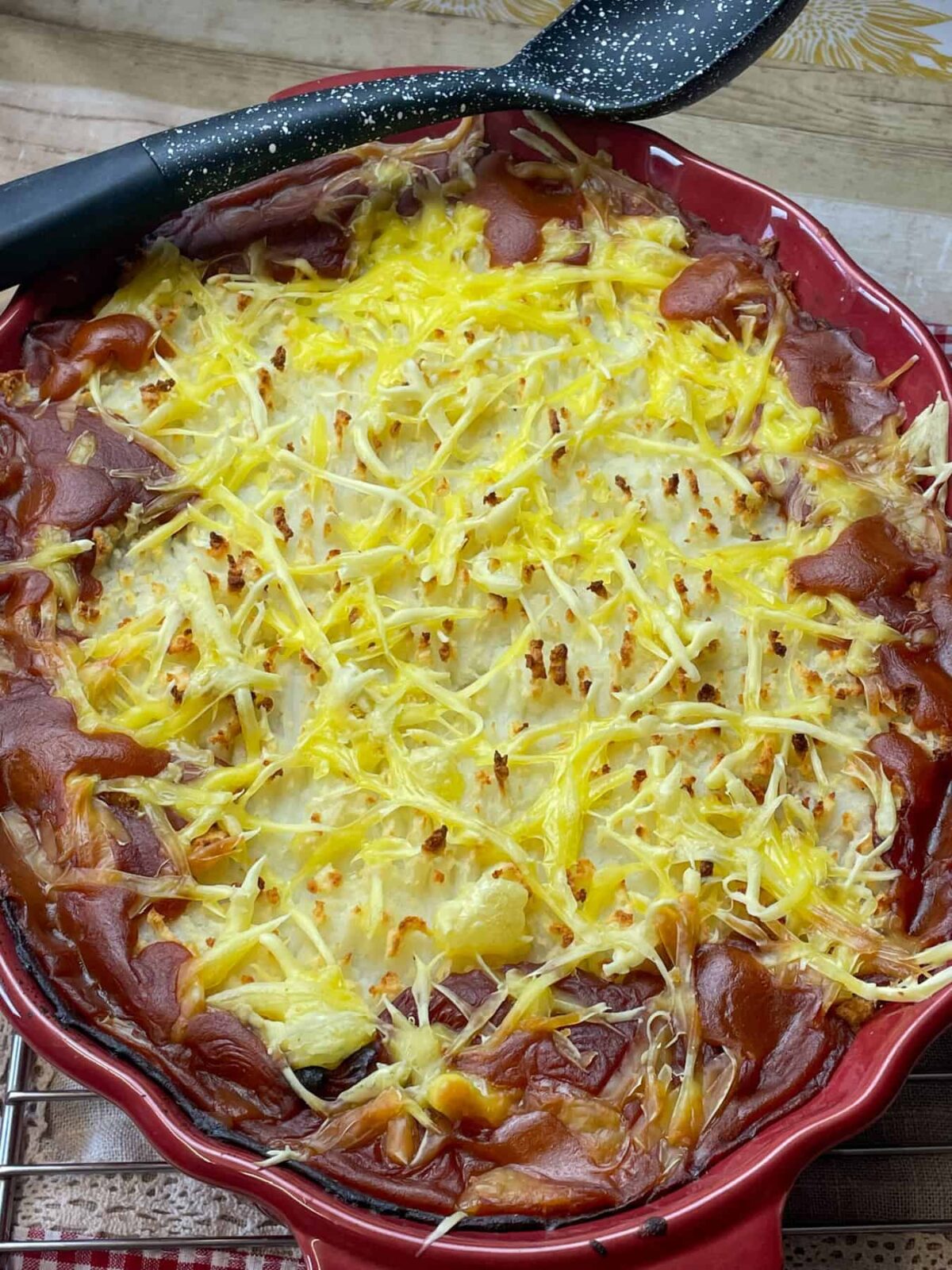 Cheese melted and pie ready to serve with black serving spoon.