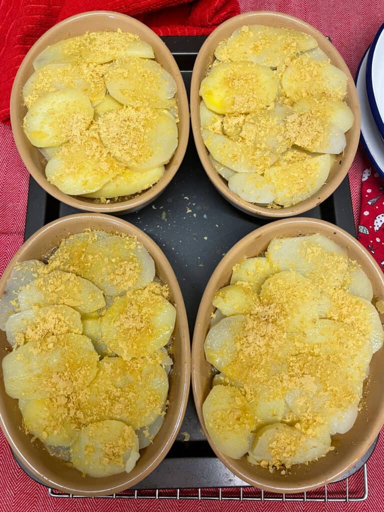 Toppings added to hotpots on baking tray.