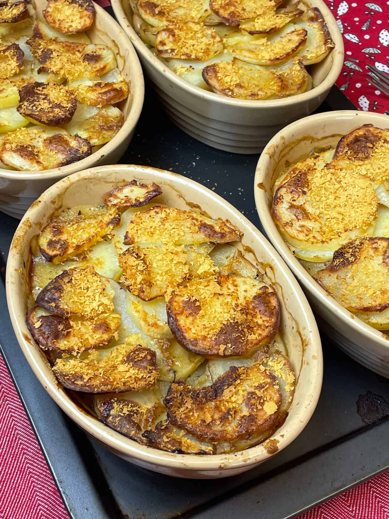 Four pie dishes of hotpot baked and on a baking tray.