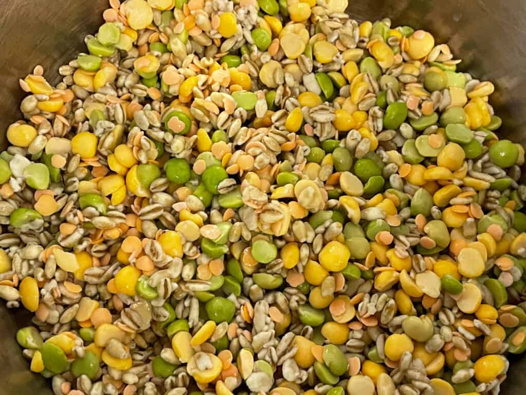 Soup or broth mix, made up with barley, split peas and red lentils all in silver soup pan.