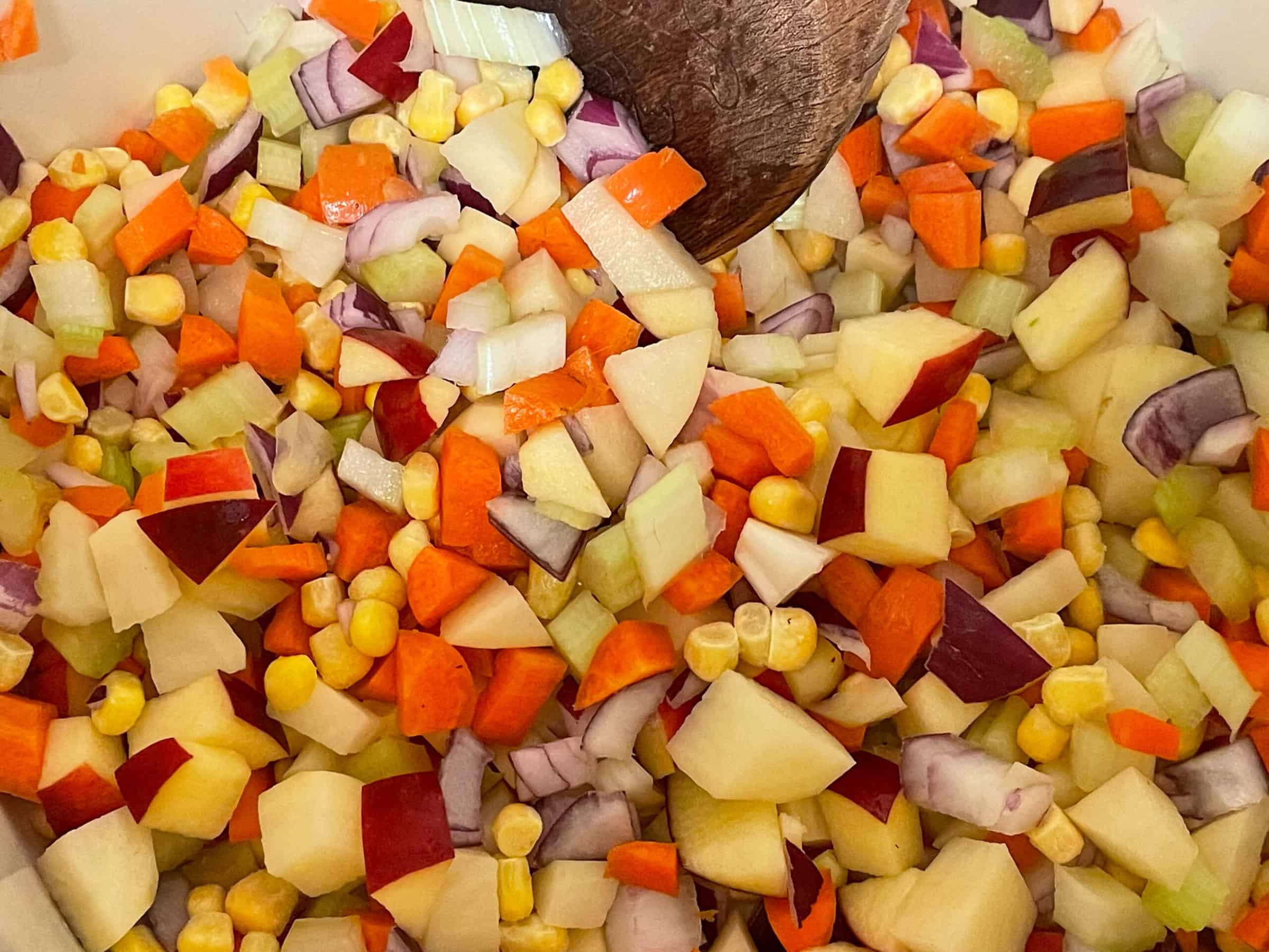 Diced veggies cooking in soup pot.