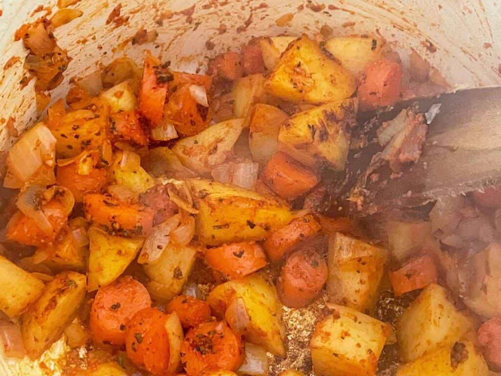 Tomato paste mixed through the potatoes and carrots.