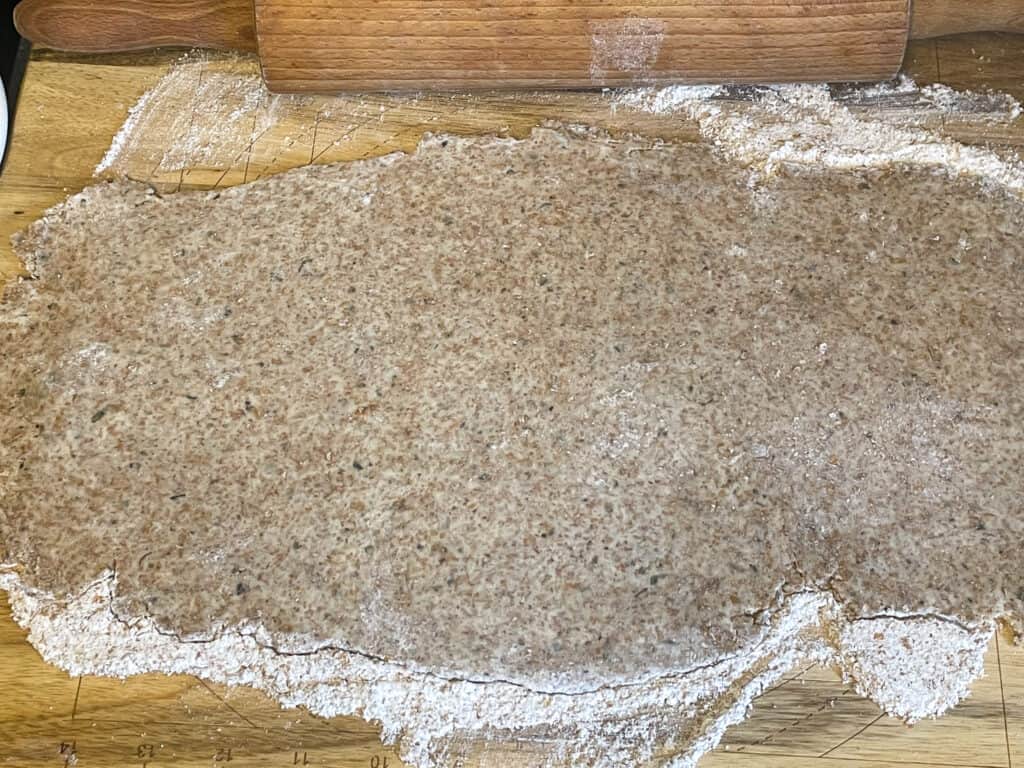 Pastry dough rolled out thin on the work surface.