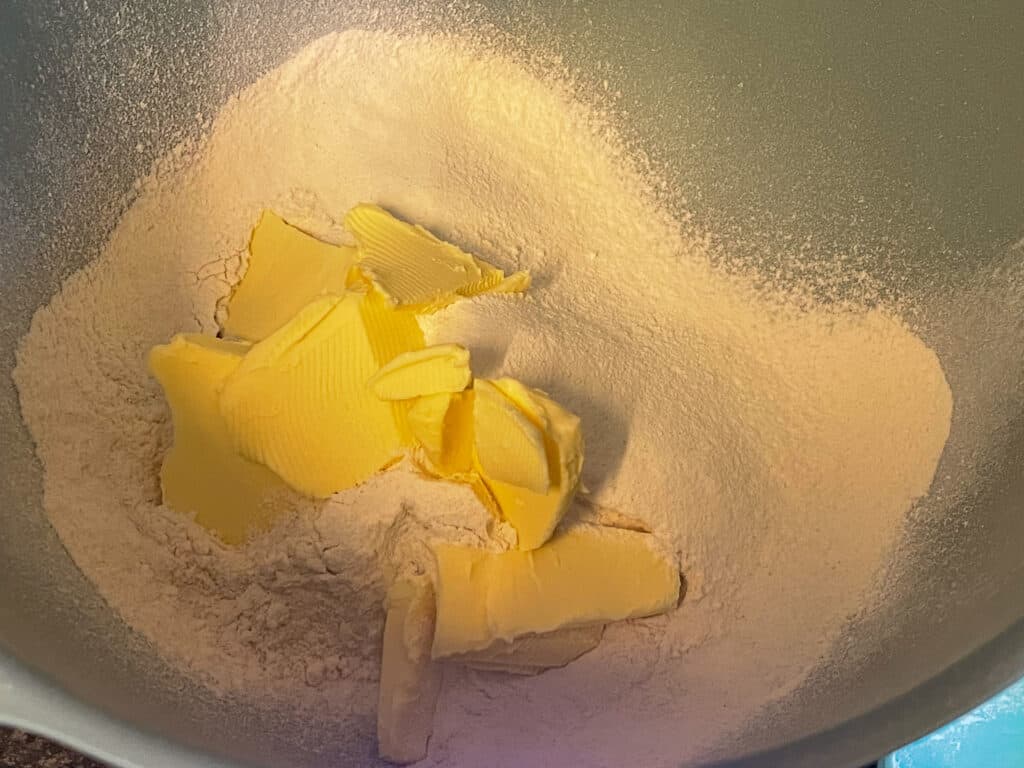 Flour, baking powder and vegan margarine in a bowl.