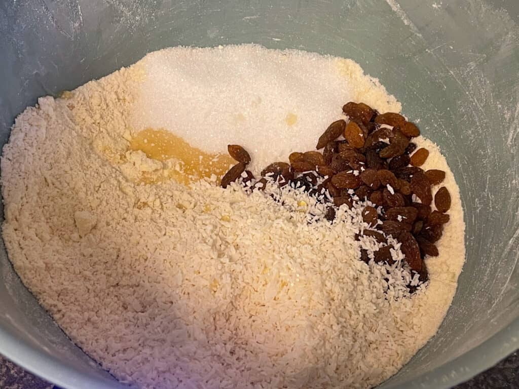 sultanas,coconut added to flour mix in bowl for vegan Jamaican coconut rock cakes.