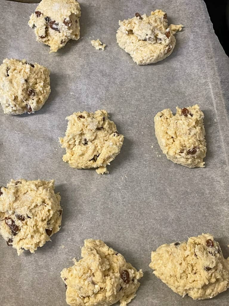 coconut rock cake dough divided into 8 pieces and placed on a baking tray.