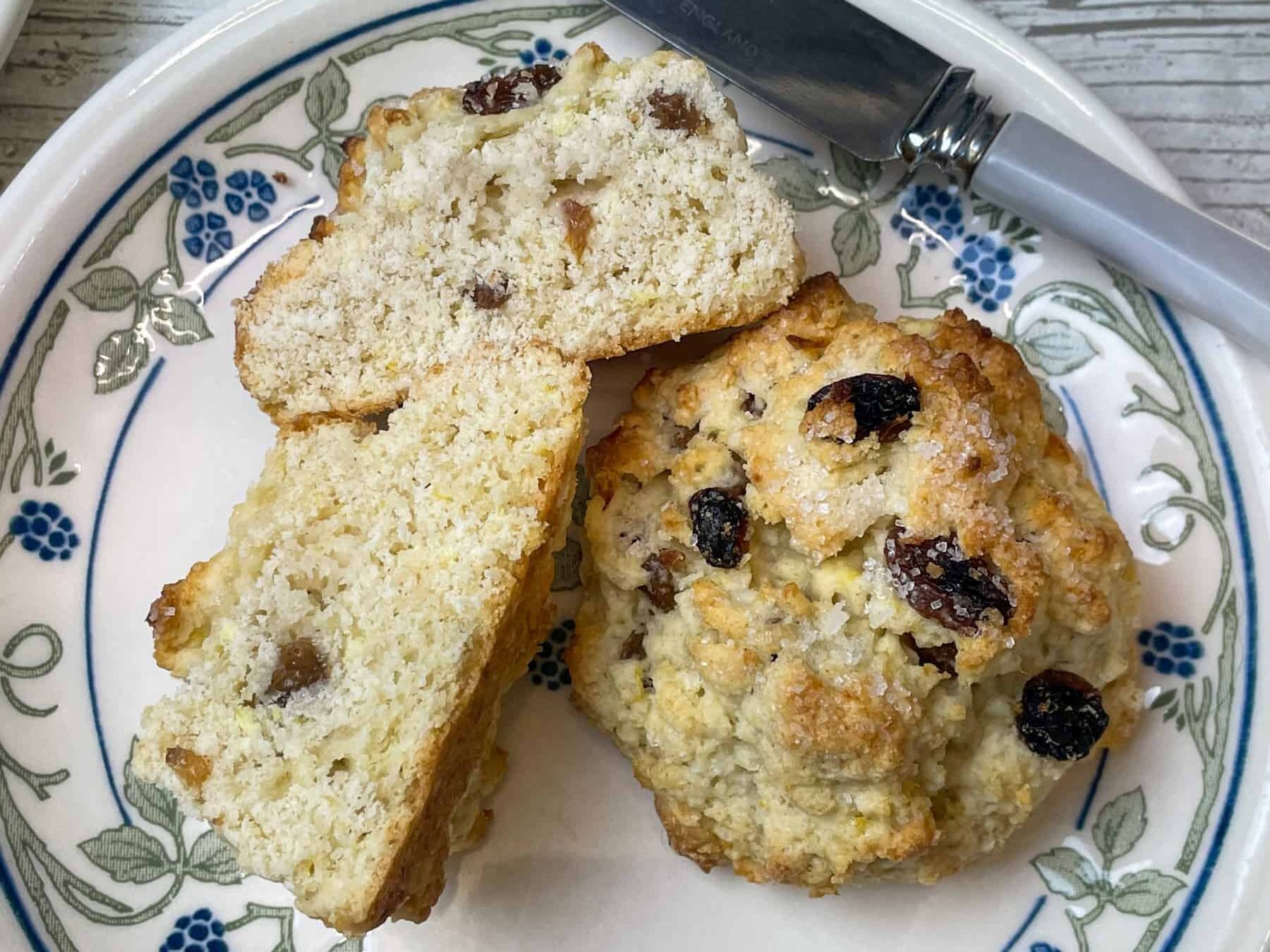 rock cakes on small plate, one rock cake split in half, dessert knife to side.