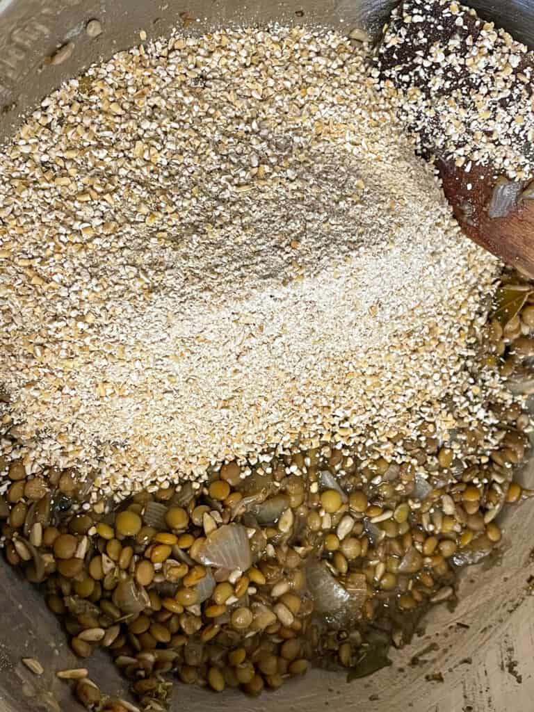 pinhead oatmeal added to lentil mix in bowl for vegan meatloaf.