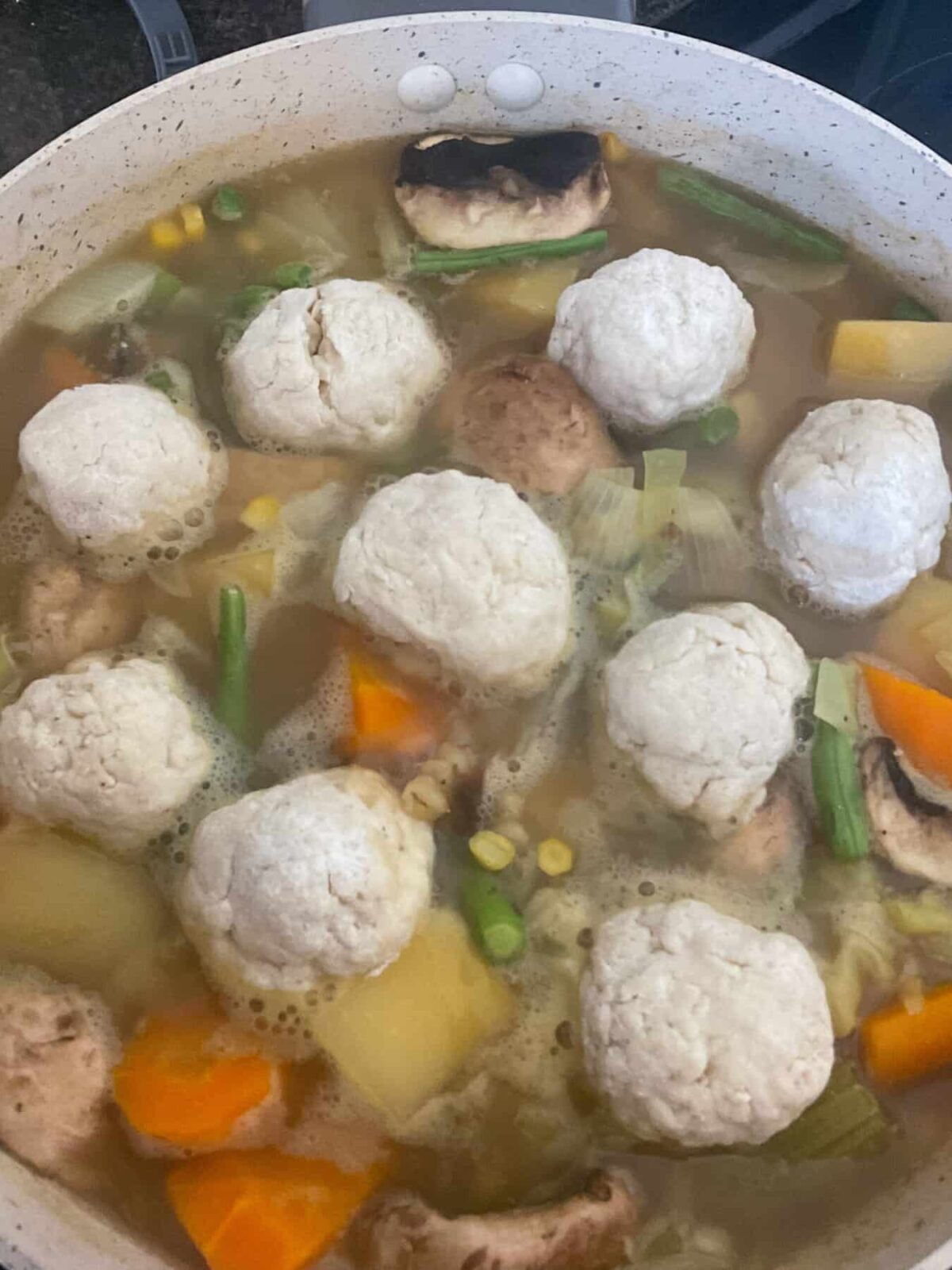 Uncooked dumplings added to vegetable stew.