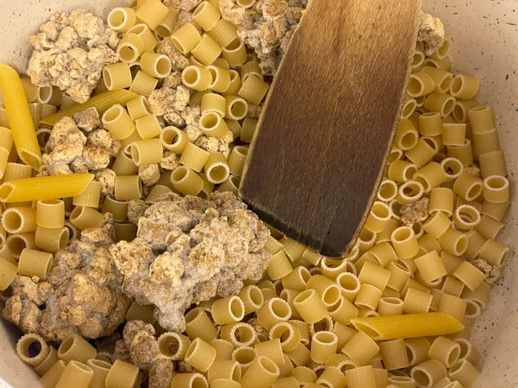 Pasta added to pot with ingredients.