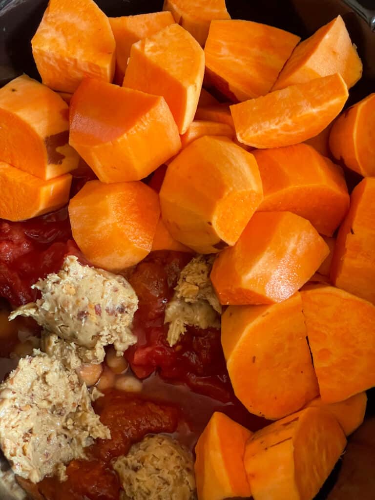 Ingredients added to the slow cooker to prepare red Thai curry.