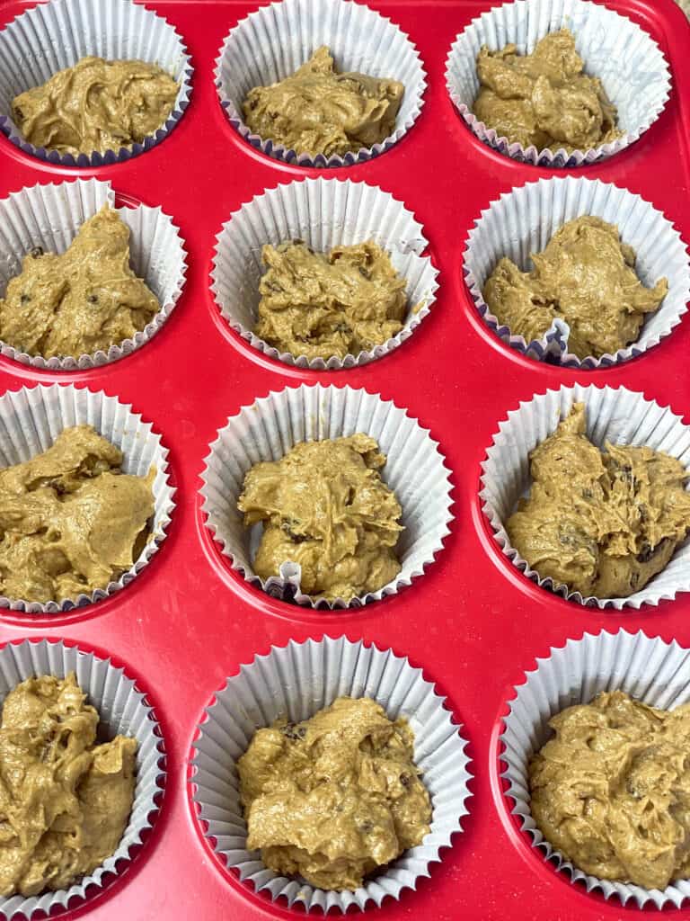 treacle bun mixture divided between twelve paper baking cases within the muffin baking tray.