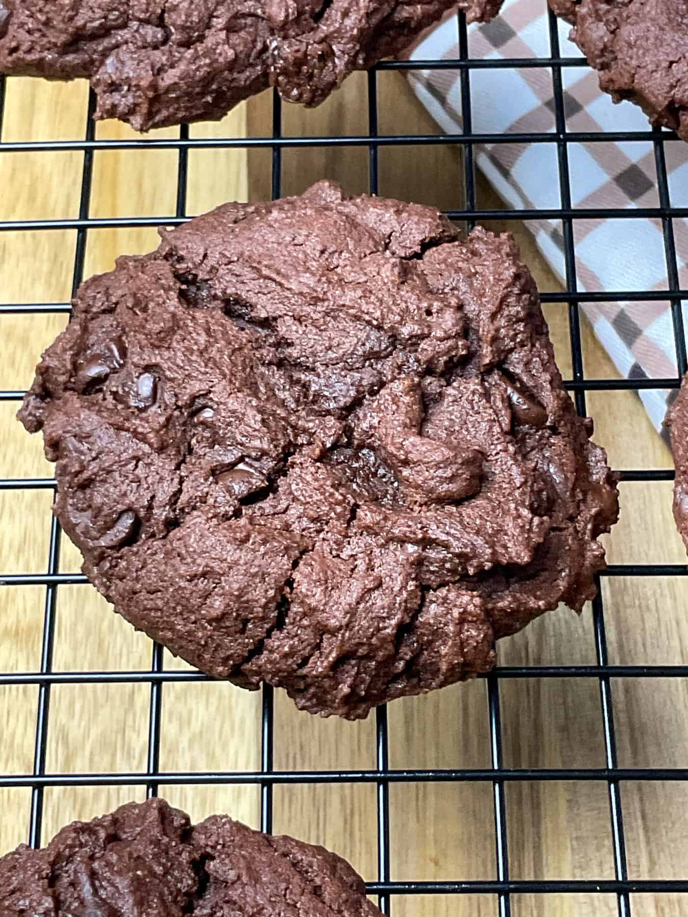 Close up of baked chocolate cookie on a cooling rack.