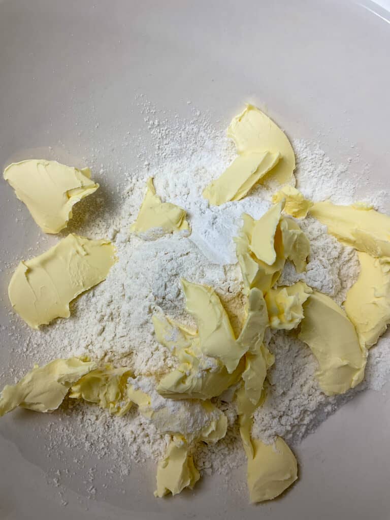 Margarine and flour added to mixing bowl for cheese flan pastry.
