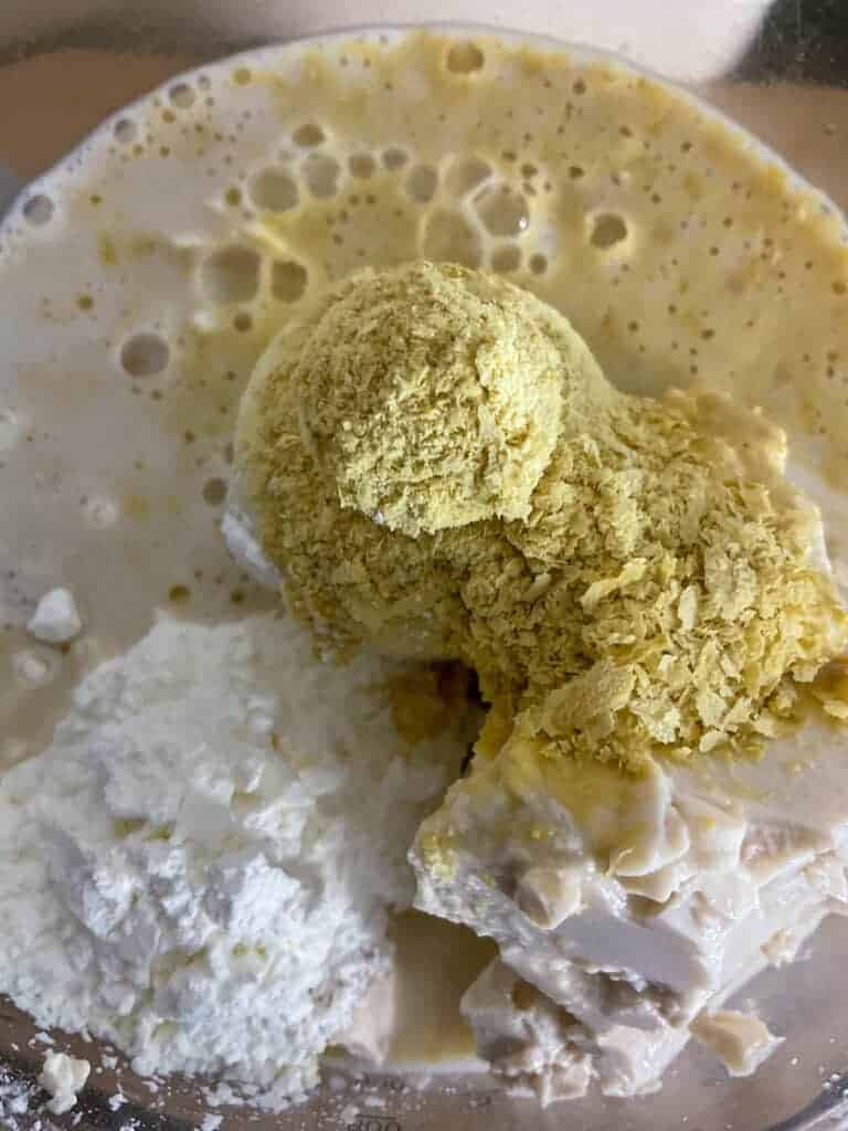 Ingredients for cheese flan filling added to small food processer ready for blending.