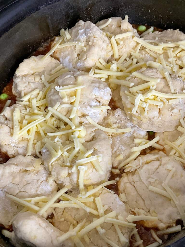 vegan cheese sprinkled over unbaked cobbler in slow cooker.