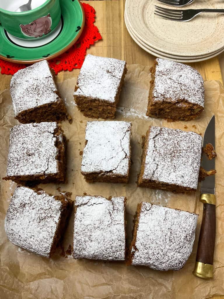 applesauce cake decorated with icing sugar and sliced into nine squares.