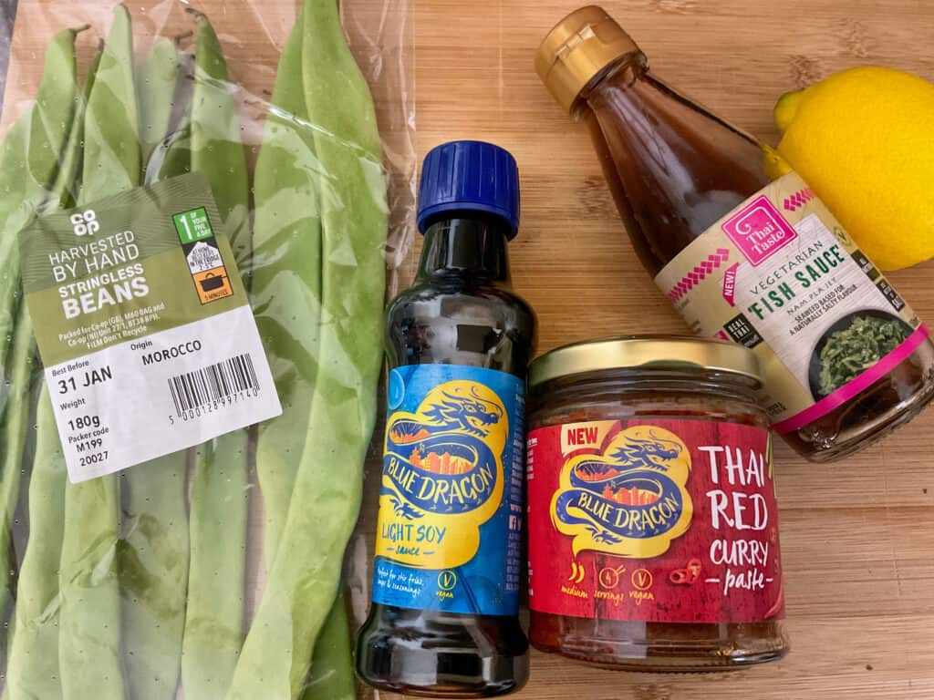 Thai red curry ingredients on a wooden board.