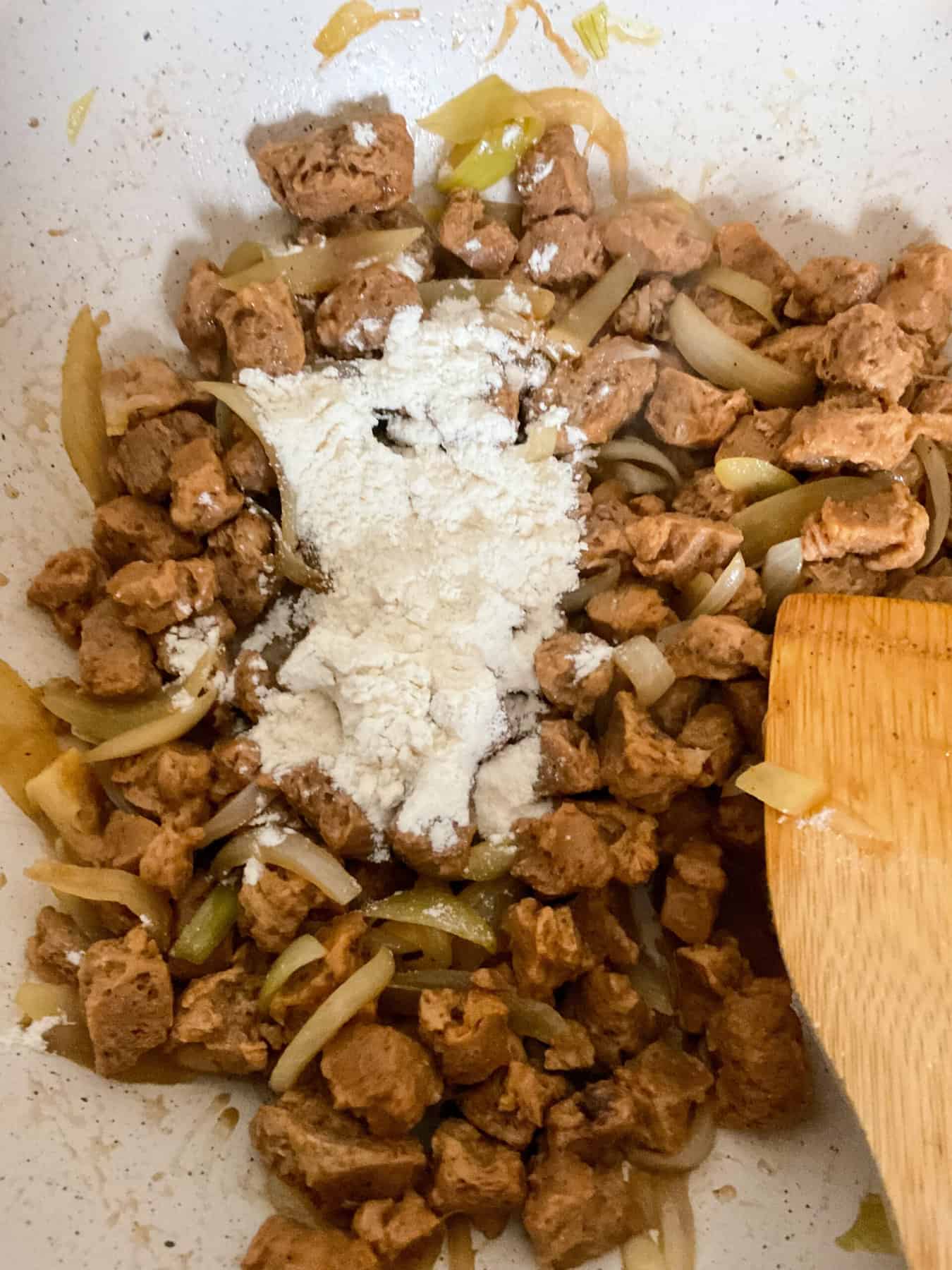 Flour added to TVP and onions in pan.