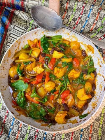 A pot of curry with serving spoon to side.