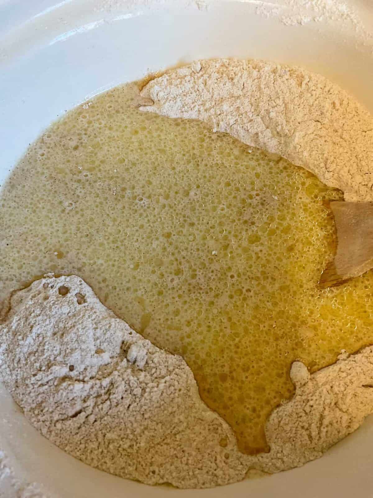 Wet ingredients poured into the dry ingredients in mixing bowl.