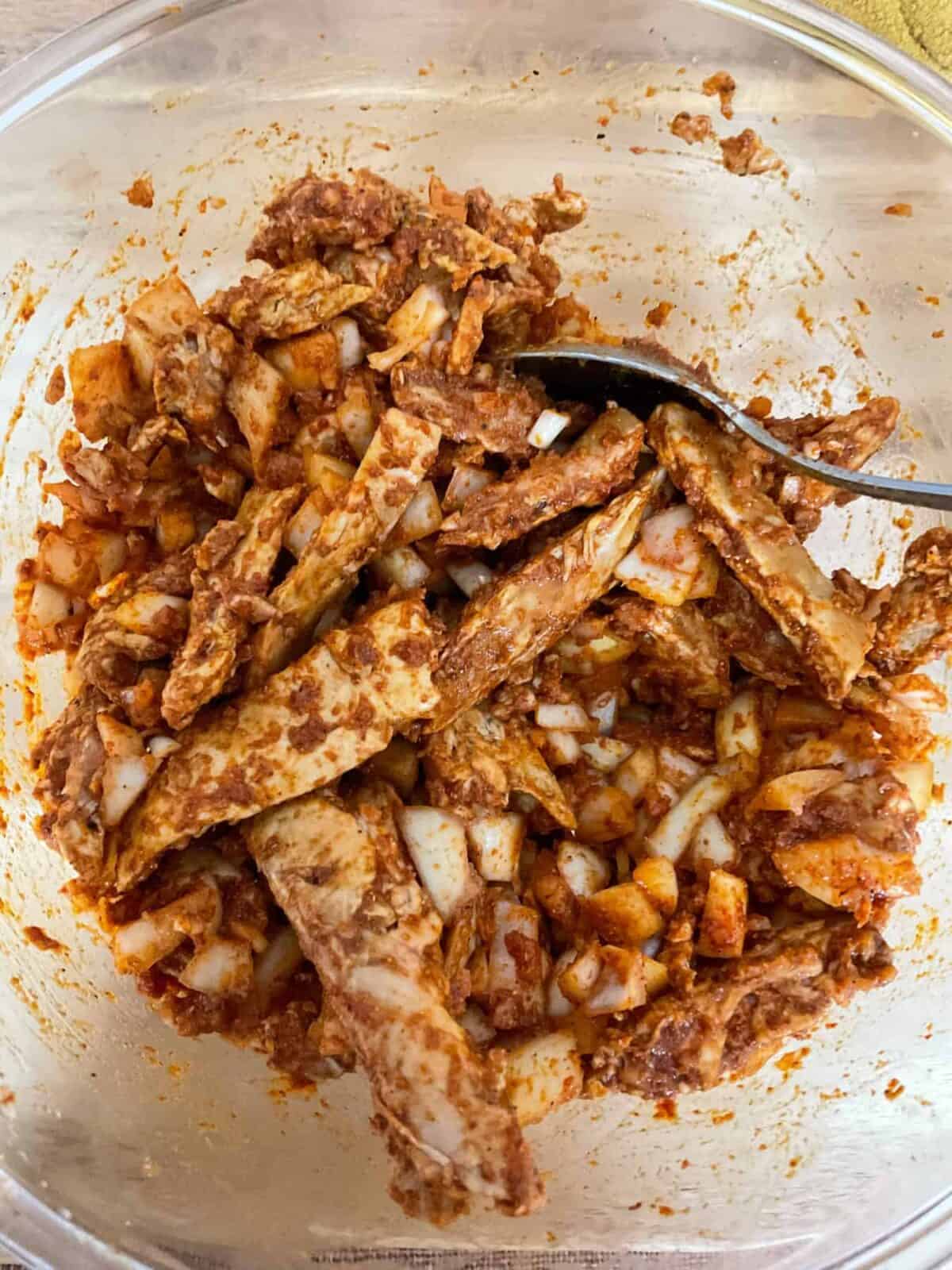 Marinade ingredients stirred together with cutlery spoon.