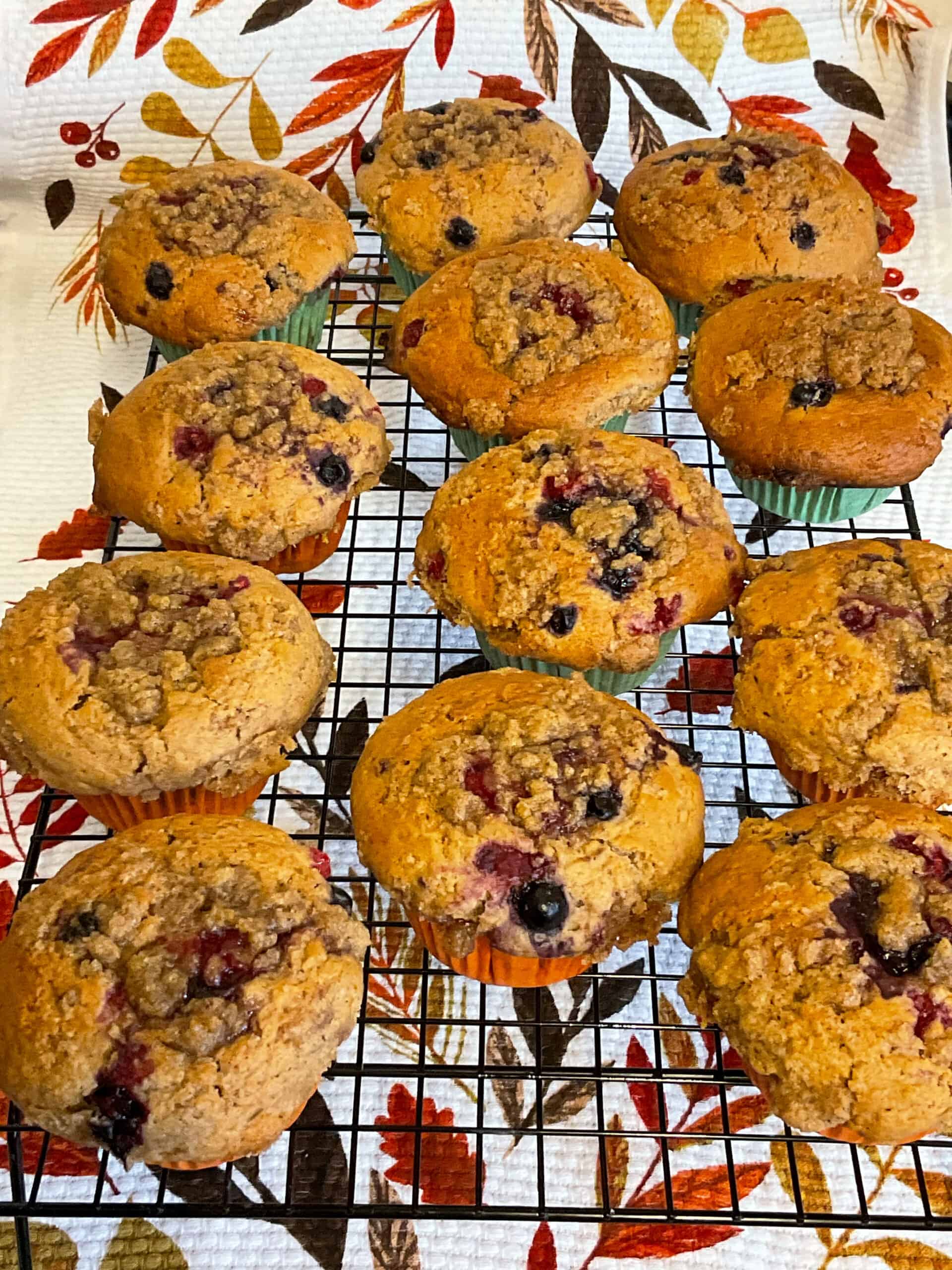 Mixed berry muffins cooling on wire rack.