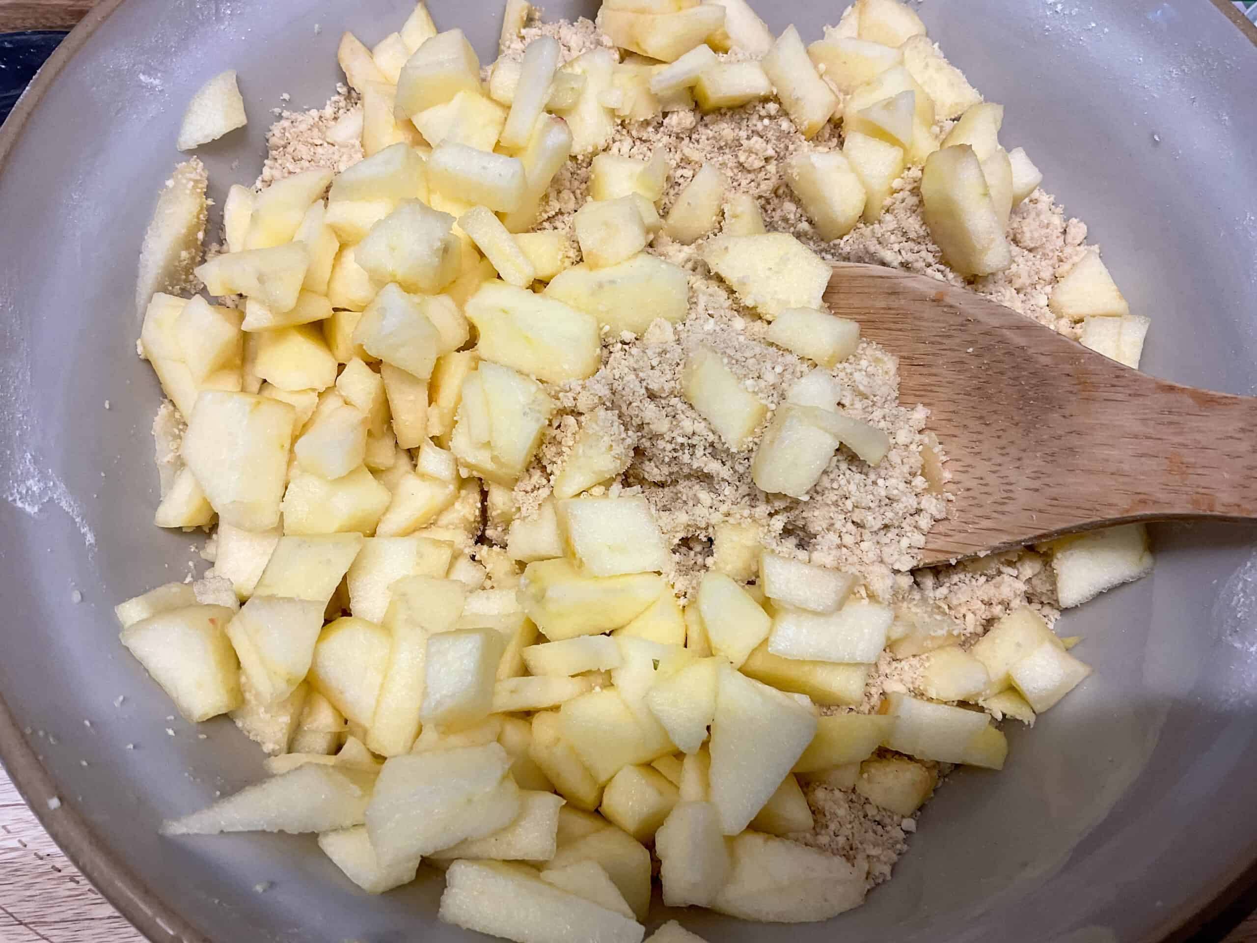 Apples added to cake mixture in bowl.