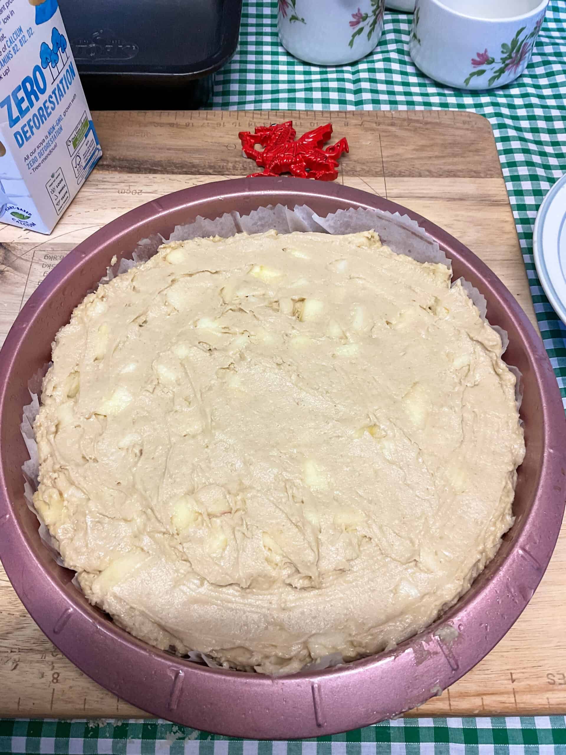 Apple cake mixture added to pink coloured cake pan.