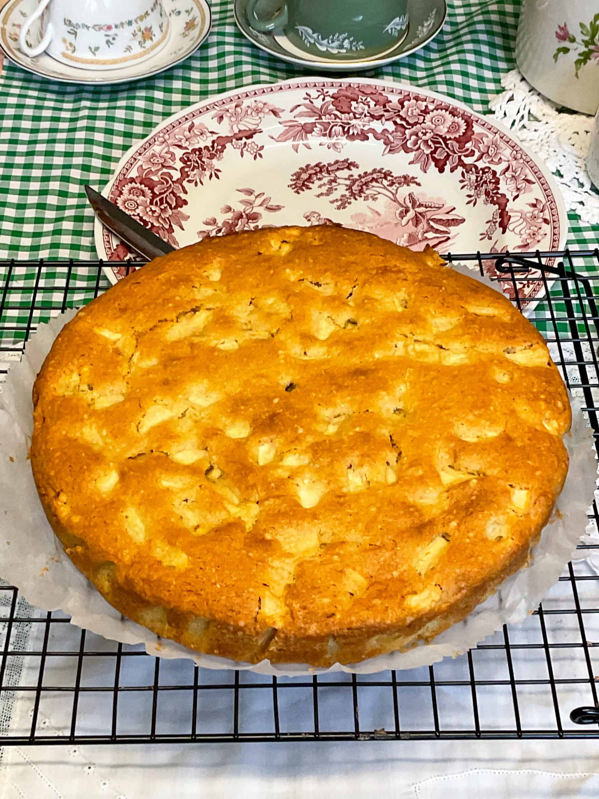 Apple cake removed from pan and sitting on wire cooling rack.