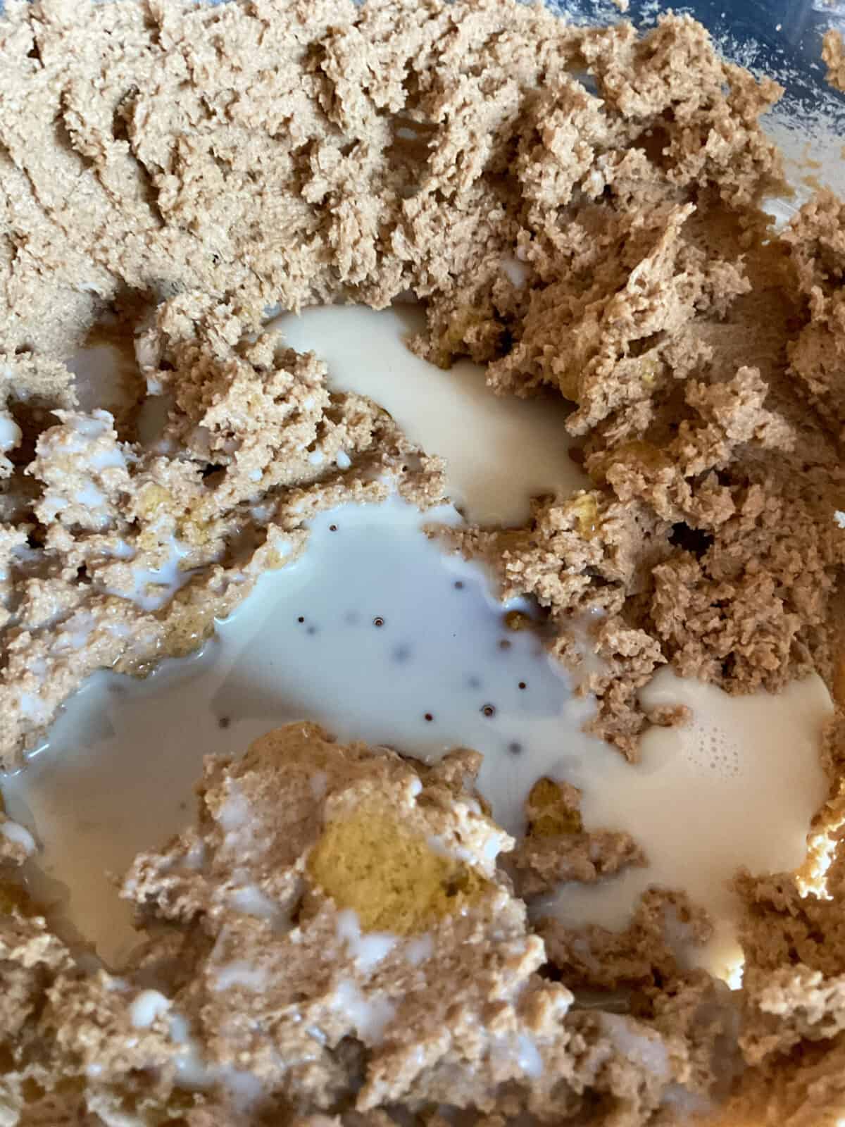 Syrup and milk added to mixed ingredients in bowl.