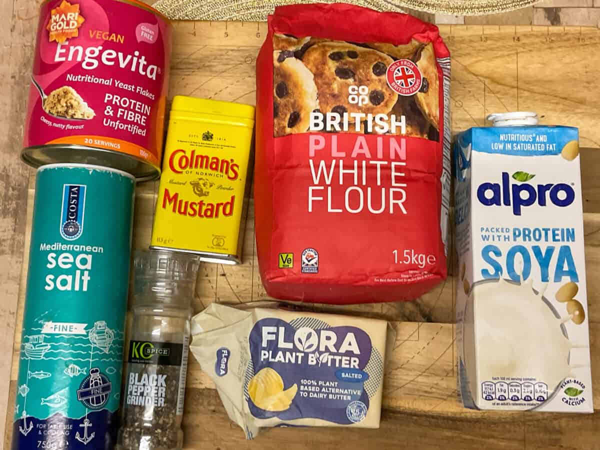 Ingredients for vegan cheese sauce on a wooden cutting board.