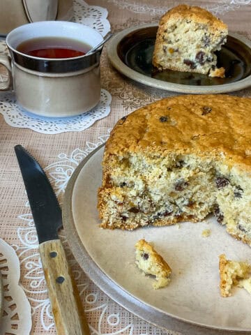 Fruit cake sliced into on a serving plate.