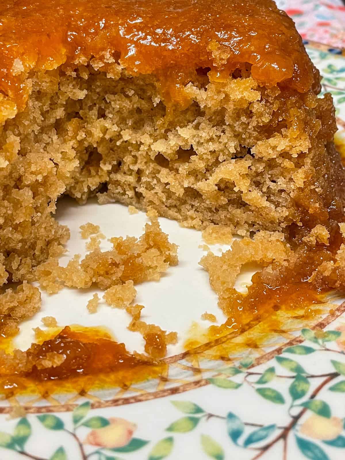 Golden syrup pudding sliced with a portion removed.