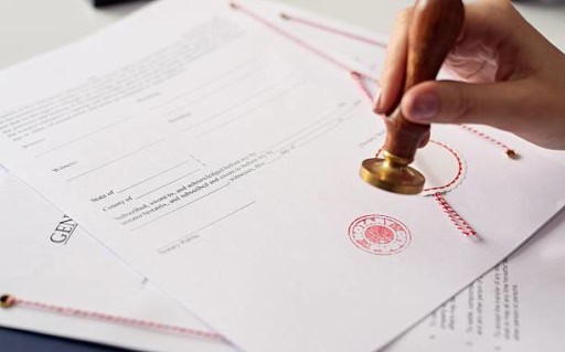 Certified legal document being stamped with a gold embossing seal, representing authentic Italian real estate transactions and property verification by Trevi Elite.