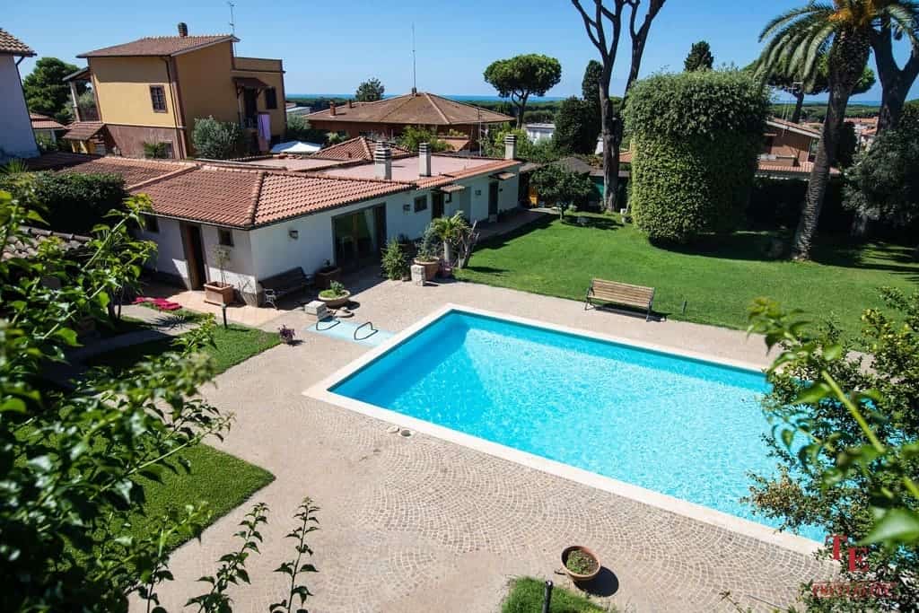 Spacious Italian villa with a private pool, lush garden, and outdoor seating area, situated in a serene residential neighbourhood with scenic views and mature trees.