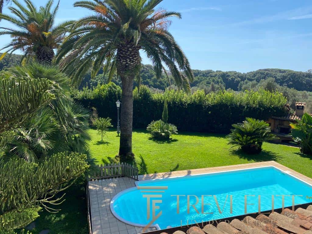 Lush Italian garden with a private swimming pool, surrounded by palm trees and vibrant greenery, showcasing luxurious outdoor living for connoisseurs of elegant Italian estates - Trevi Elite.