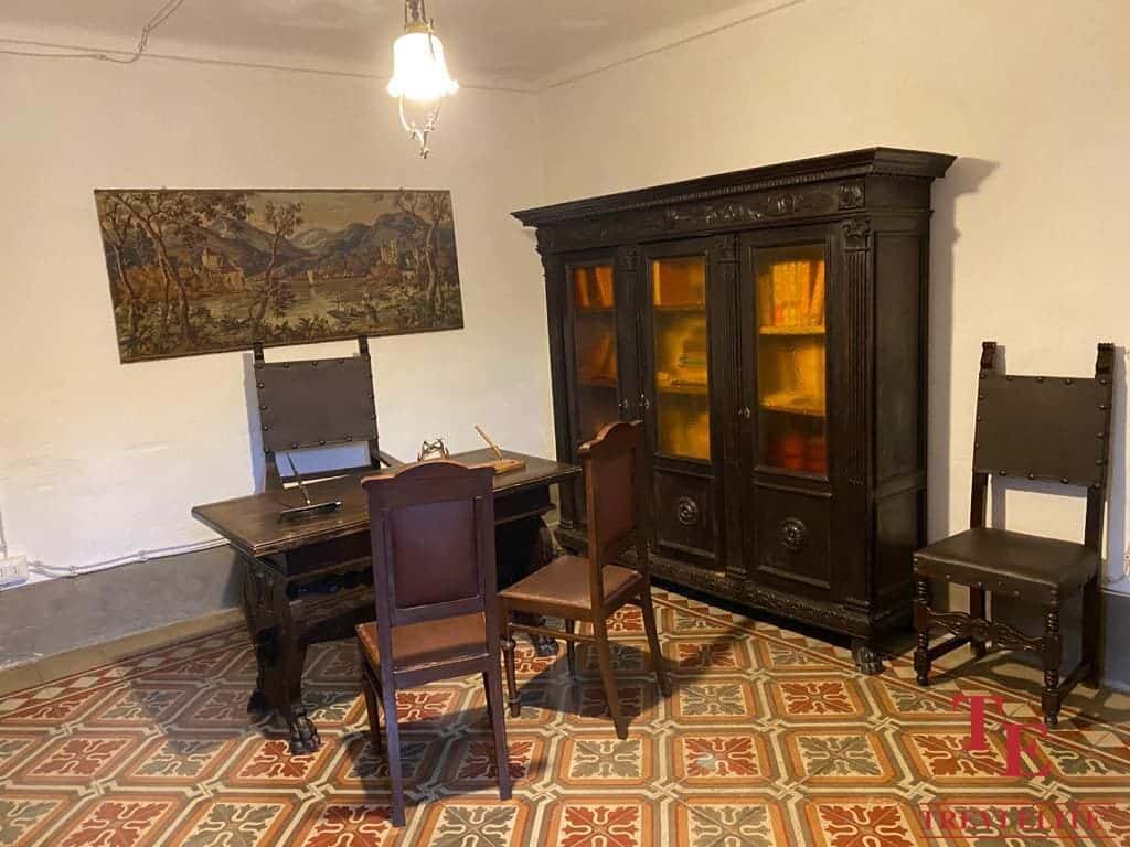 Antique Italian wooden cabinet with glass doors in classic interior design.