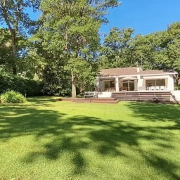 Modern Italian villa with spacious garden and lush greenery, perfect for luxurious outdoor living. Elegant architecture with large windows, blending indoor comfort with nature.