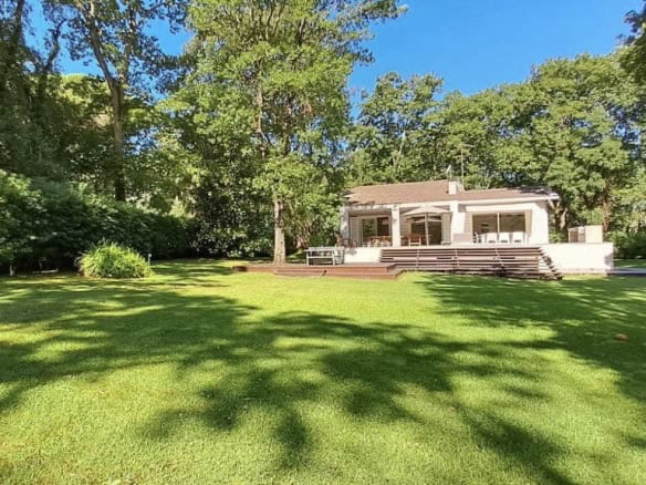 Modern Italian villa with spacious garden and lush greenery, perfect for luxurious outdoor living. Elegant architecture with large windows, blending indoor comfort with nature.