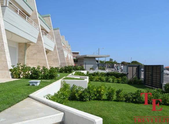 Luxurious modern apartment building with manicured gardens and spacious terraces in a prime Italian location.
