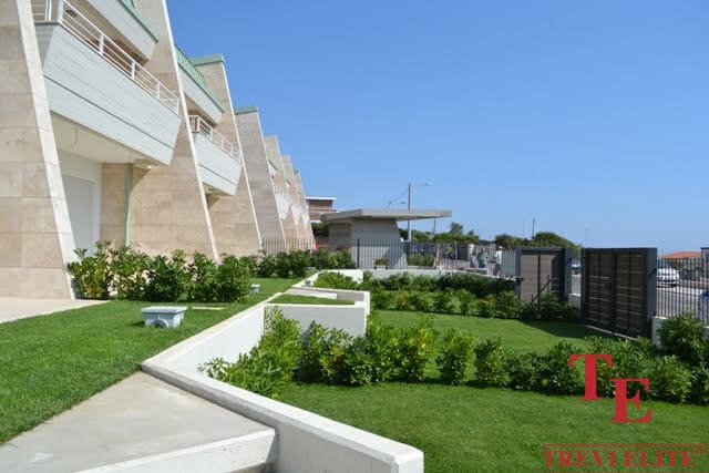 Luxurious modern apartment building with manicured gardens and spacious terraces in a prime Italian location.