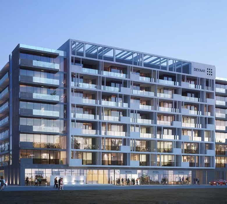 Luxurious modern multi-storey building with extensive glass facade and spacious balconies, set against a clear blue sky in a tropical urban environment.