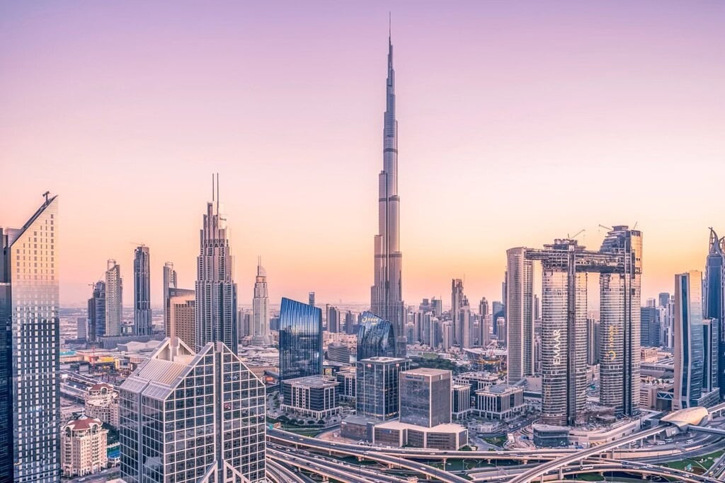 Stunning panoramic view of Dubai skyline featuring the iconic Burj Khalifa at sunset, showcasing luxurious modern skyscrapers and vibrant city life.