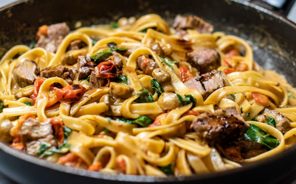 Succulent Italian beef and vegetable pasta dish in a rich sauce, featuring tender meat, ripe tomatoes, and fresh herbs for a hearty and authentic flavour experience for luxury connoisseurs - Trevi Elite.