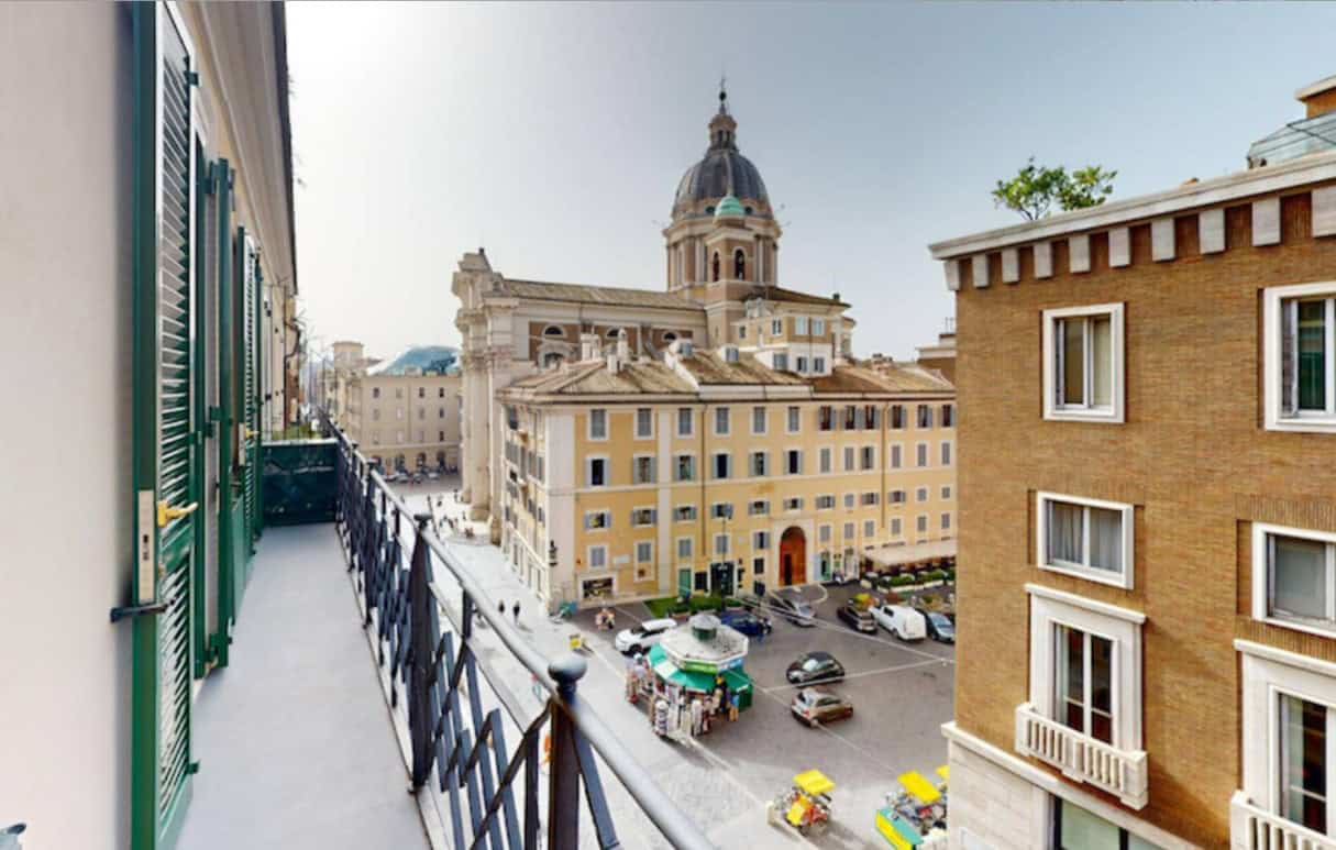 Stunning view from an Italian apartment balcony overlooking historic buildings and a city square in Rome.