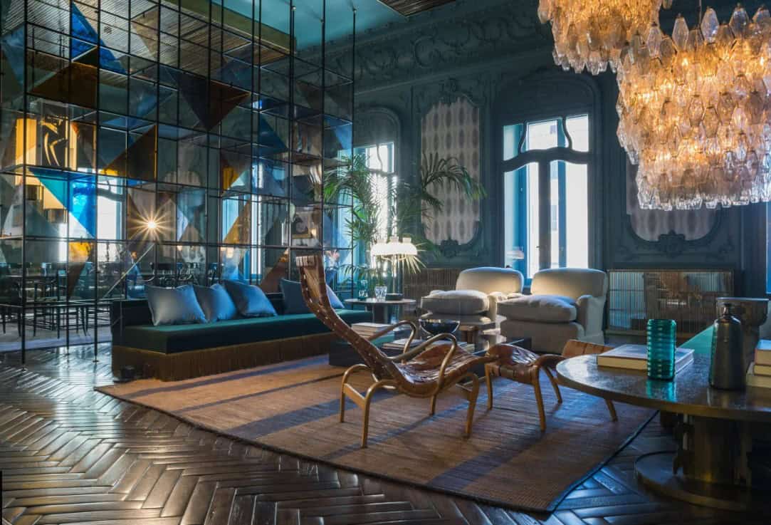 Luxurious living room with ornate architectural details, elegant furniture, and a stunning chandelier in a high-end Italian estate. The space combines vintage charm with modern luxury decor.